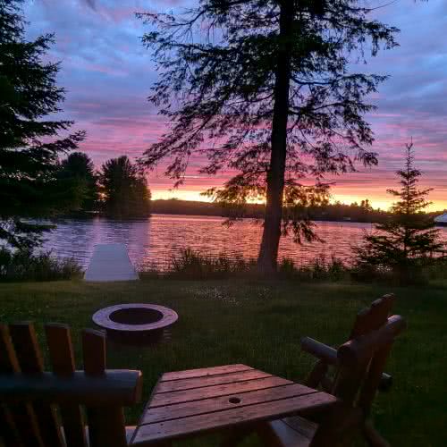 Der Grill- und Essbereich im Freien bei Smile Awhile ist ideal f&uuml;r sommerliche Grillabende und Familienessen inmitten von Natur und hohen Kiefern.